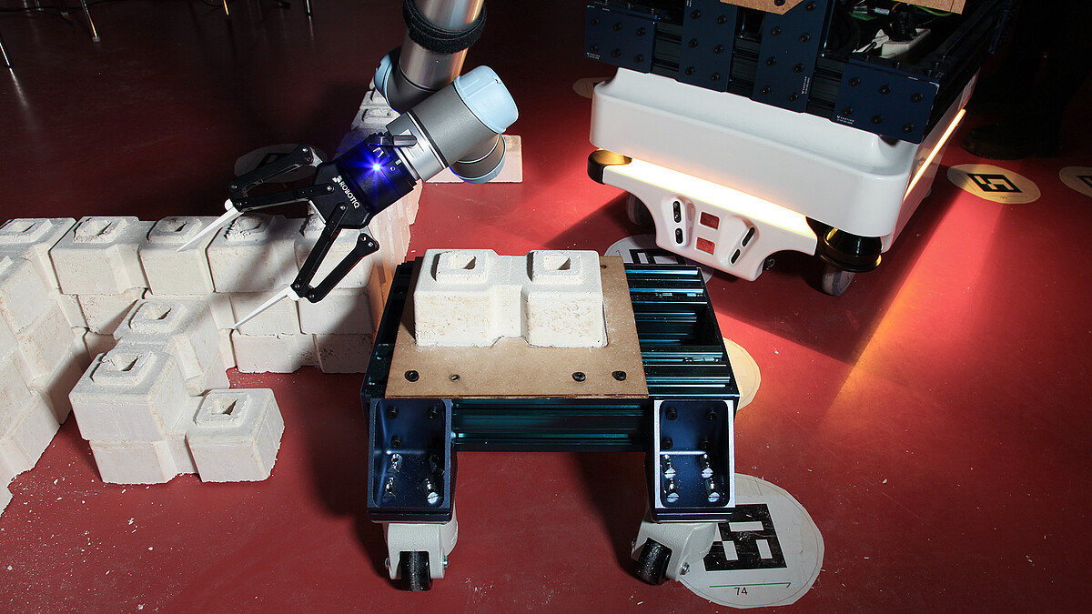 Roboterarm auf mobiler Plattform baut Wand